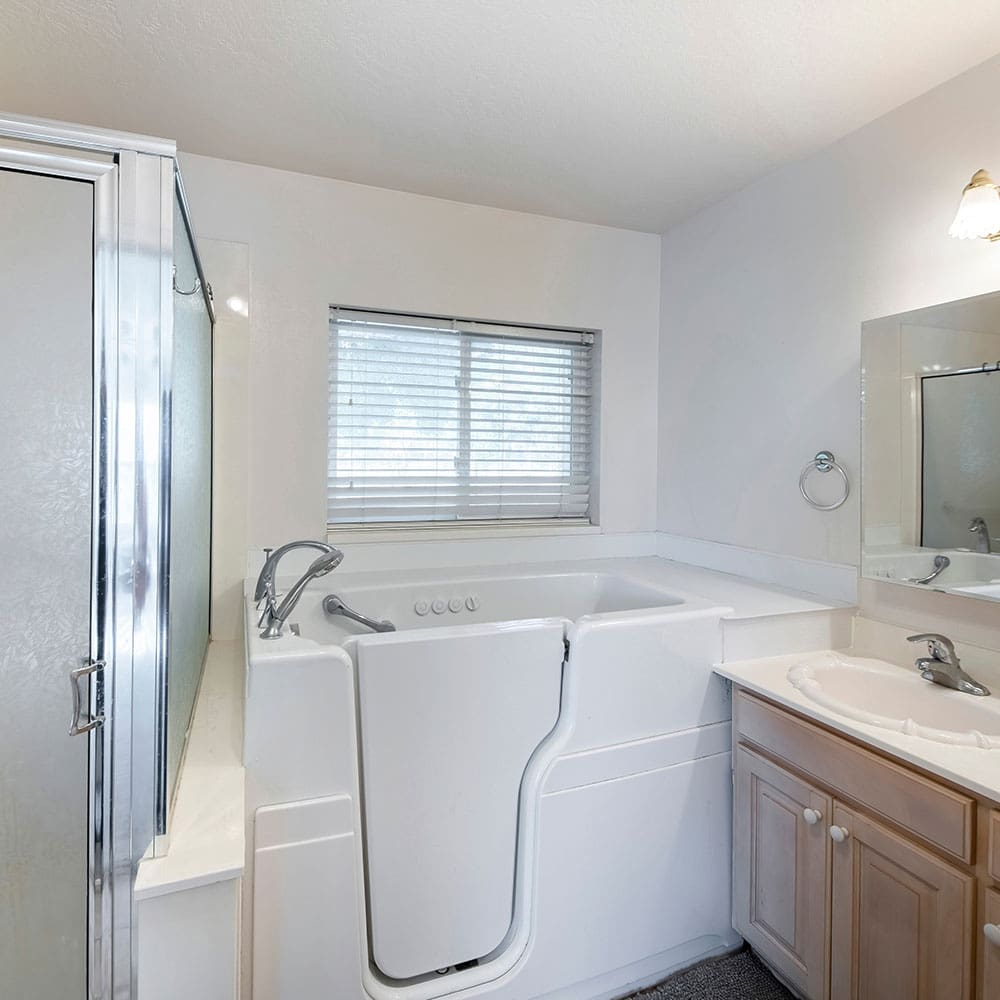 Walk-in tub with a low threshold and door installed in a bathroom