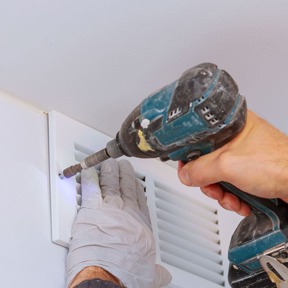 Technician cleaning a home air duct and vent system